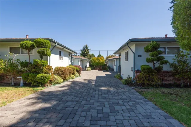 a front view of a house with a yard and potted plants