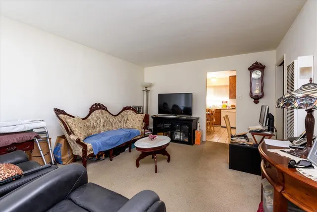 a living room with furniture a flat screen tv and a window