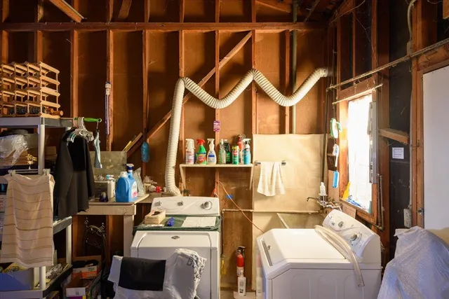 a utility room with dryer washer and a view of living room
