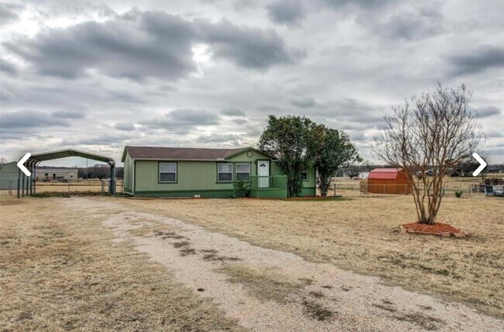 View of front of home featuring a detached carport and driveway