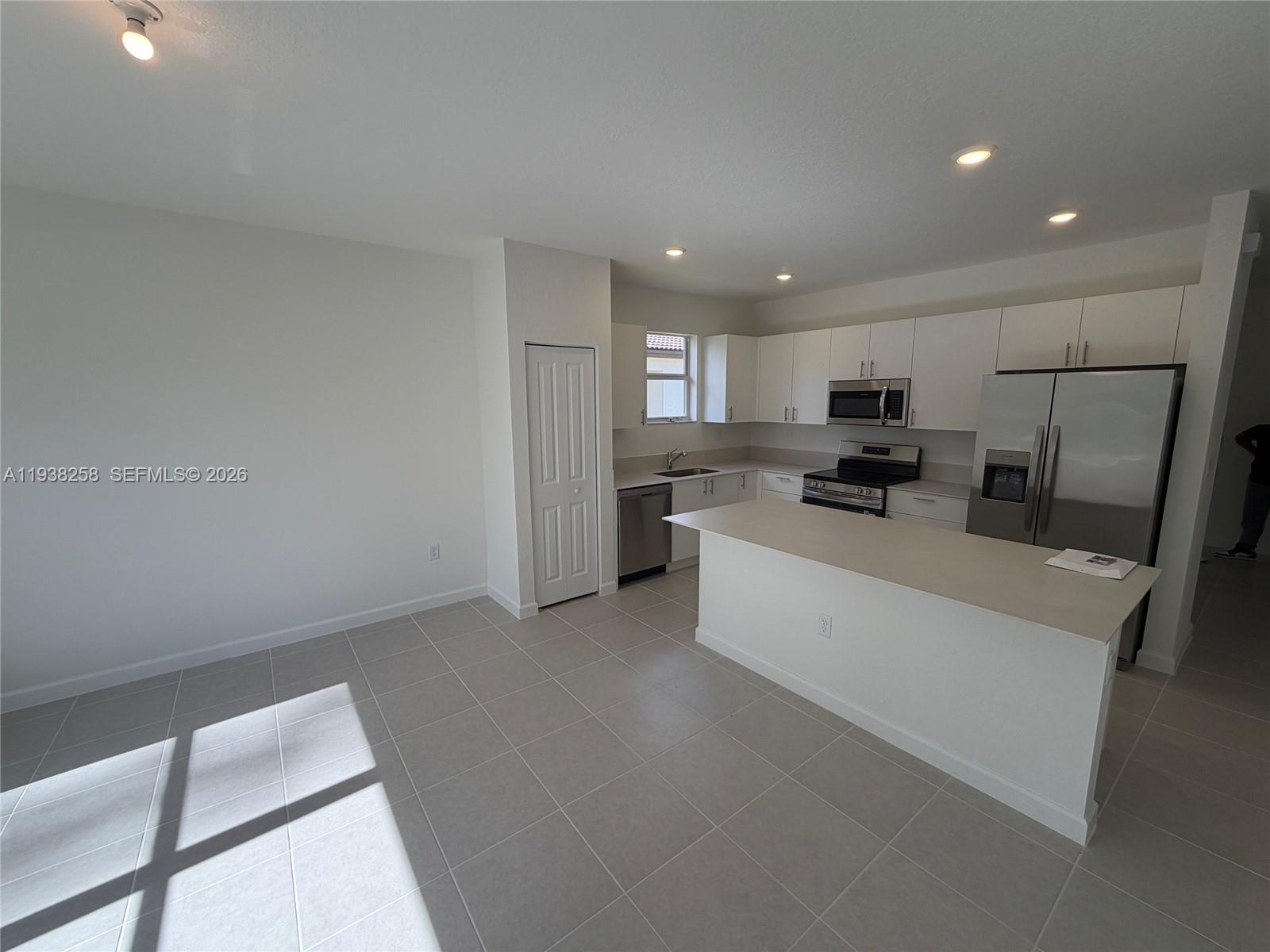 2256 Southeast 30th Street, Unit 2256 Homestead, FL 33035 - Photo 7 of 29 a large white kitchen with stainless steel appliances a refrigerator a stove a microwave and cabinets