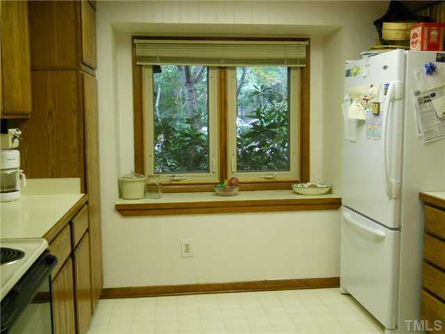 4347 Sunscape Lane Raleigh, NC 27613 - Photo 6 of 14 Sunny and spacious kitchen showing pantry and refrigerator that remains with home.