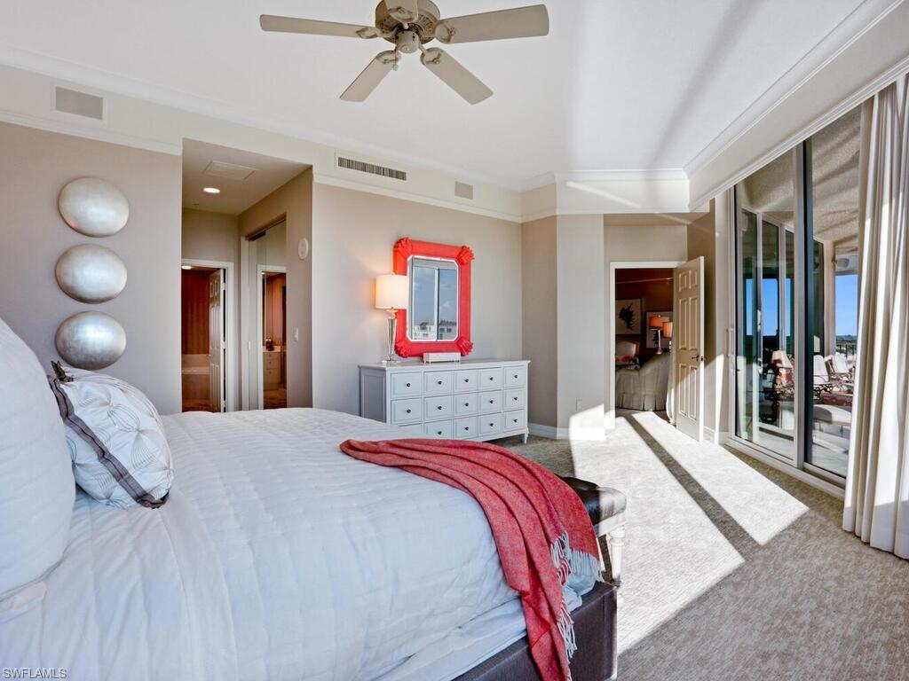 425 Dockside Drive, Unit PH1 Naples, FL 34110 - Photo 11 of 34 a bedroom with a large bed and a chandelier
