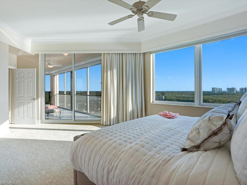 425 Dockside Drive, Unit PH1 Naples, FL 34110 - Photo 12 of 34 a bed sitting in a spacious bedroom next to a window