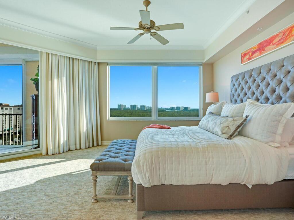 425 Dockside Drive, Unit PH1 Naples, FL 34110 - Photo 13 of 34 a bedroom with a bed and a chandelier