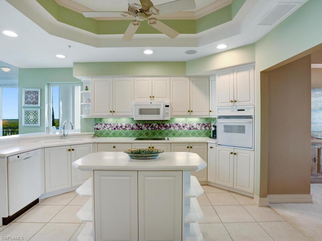 425 Dockside Drive, Unit PH1 Naples, FL 34110 - Photo 18 of 34 a kitchen with cabinets and chairs
