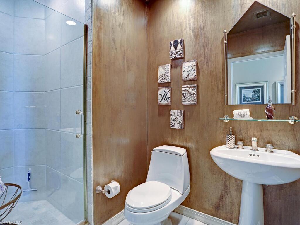 425 Dockside Drive, Unit PH1 Naples, FL 34110 - Photo 27 of 34 a white toilet sitting next to a bathroom sink