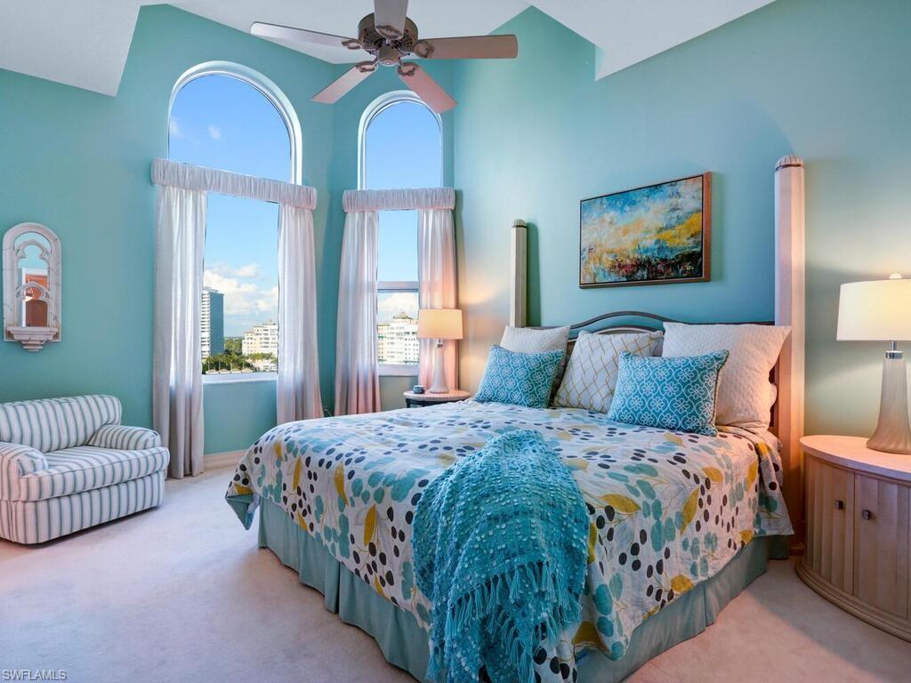 425 Dockside Drive, Unit PH1 Naples, FL 34110 - Photo 28 of 34 a bedroom with bed and a chandelier