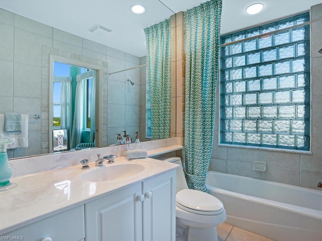 425 Dockside Drive, Unit PH1 Naples, FL 34110 - Photo 29 of 34 a bathroom with a double vanity sink toilet mirror and bathtub