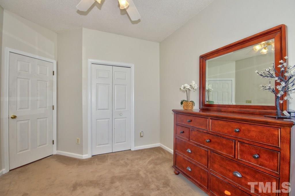 12225 Jarden Court Raleigh, NC 27613 - Photo 15 of 20 a room with a bed and a mirror on dresser