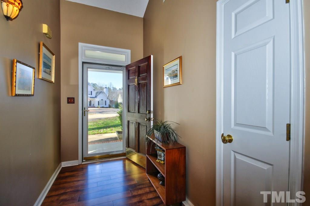 12225 Jarden Court Raleigh, NC 27613 - Photo 4 of 20 a view of a hallway with wooden floor and a livingroom