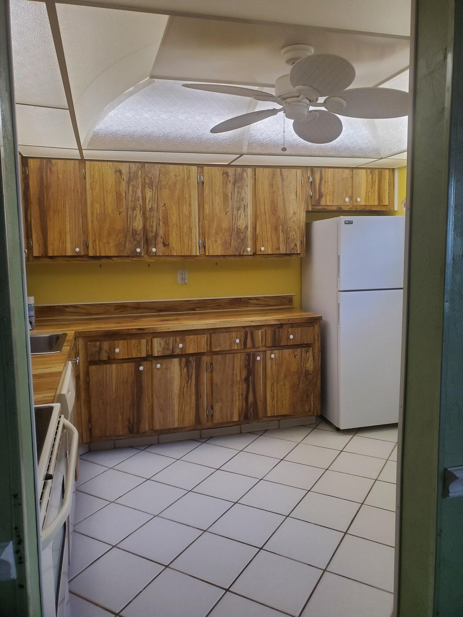 214 Capri East Delray Beach, FL 33484 - Photo 2 of 20 a kitchen with a refrigerator and a sink