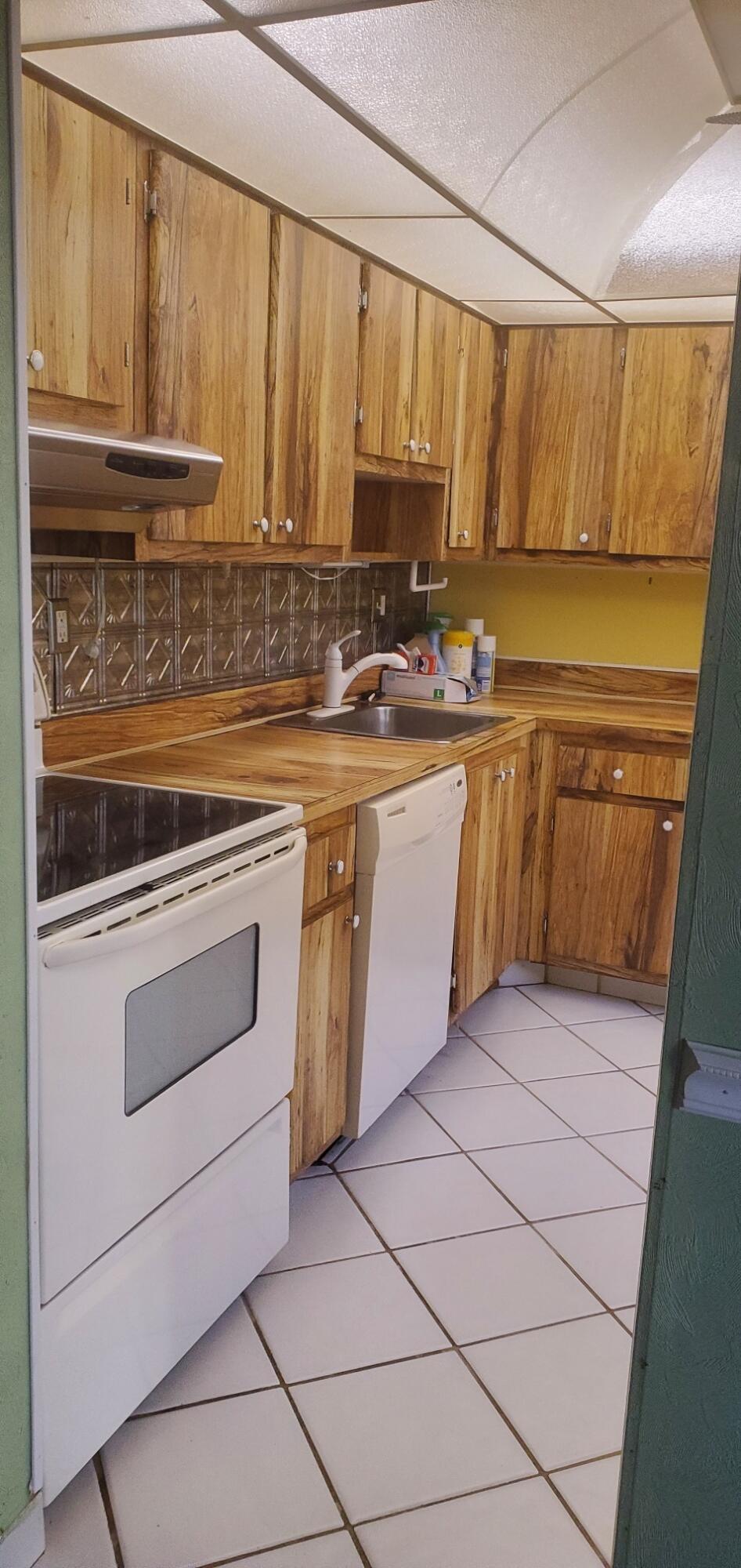 214 Capri East Delray Beach, FL 33484 - Photo 5 of 20 a kitchen with stainless steel appliances granite countertop a sink and cabinets