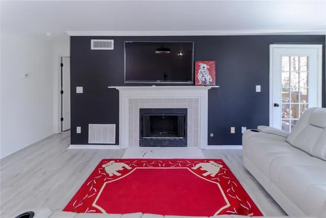 a living room with a rug and a fireplace