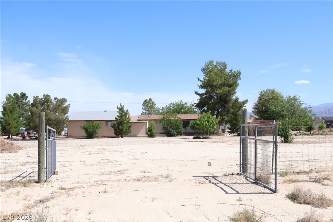 4501 East Kellogg Road Pahrump, NV 89061 - Photo 43 of 52 A spacious desert property offering a tranquil escape with a gated entrance and natural landscaping.