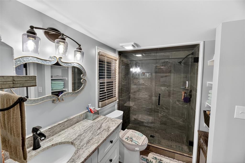 76 Walker Road Northwest Cartersville, GA 30121 - Photo 22 of 33 a bathroom with a granite countertop sink a toilet and shower
