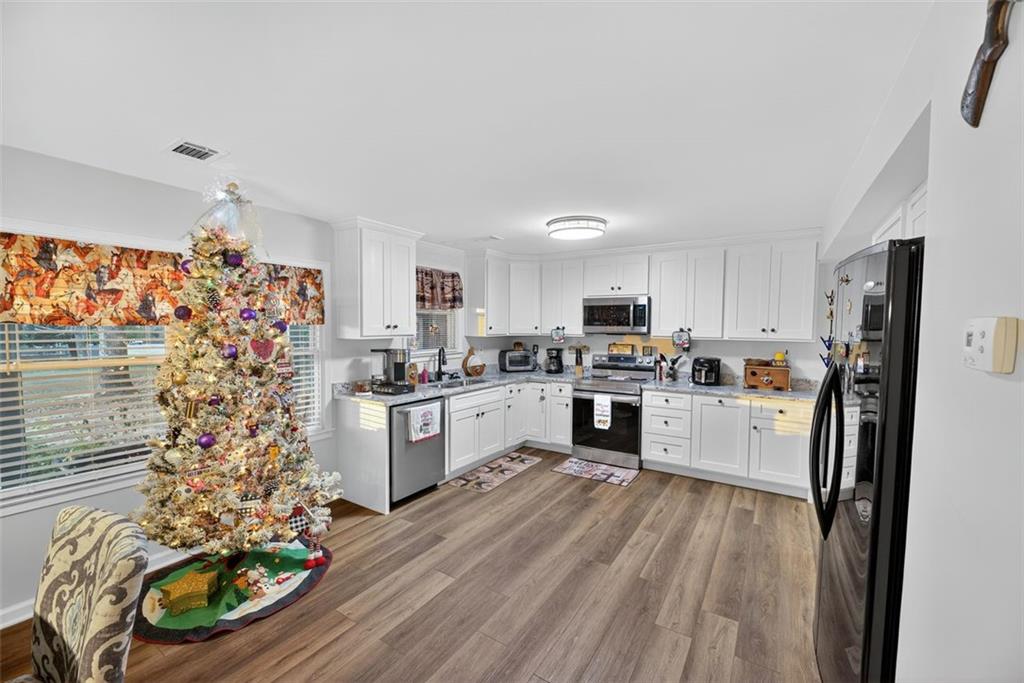 76 Walker Road Northwest Cartersville, GA 30121 - Photo 9 of 33 a kitchen with stainless steel appliances kitchen island granite countertop a refrigerator and a stove top oven