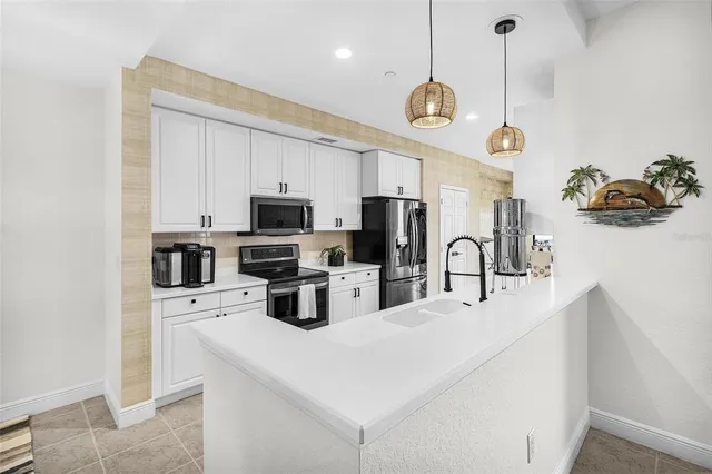 a kitchen with stainless steel appliances a refrigerator sink and microwave
