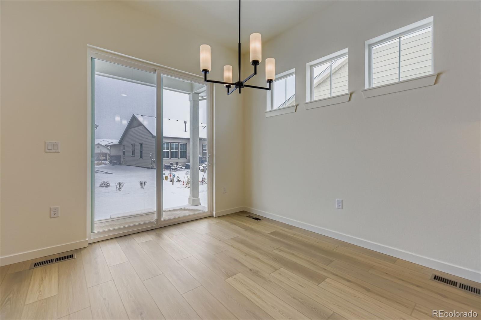 8942 South Riviera Way Aurora, CO 80016 - Photo 12 of 29 a view of empty room with wooden floor and cabinet