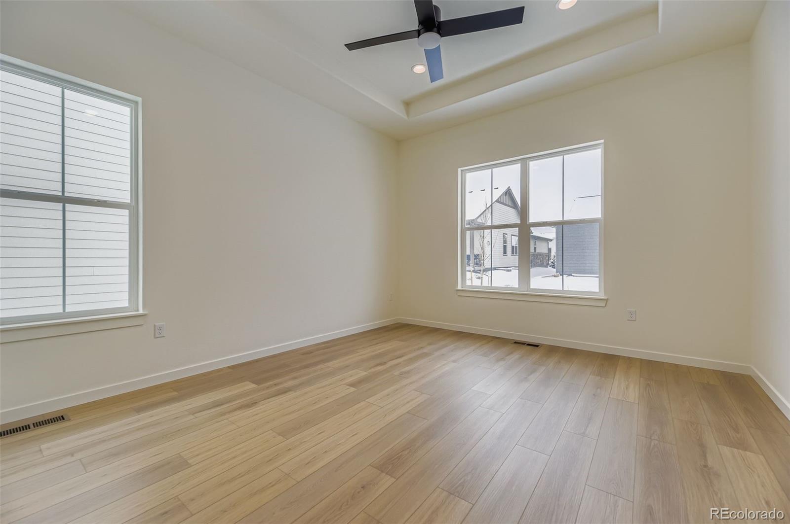 8942 South Riviera Way Aurora, CO 80016 - Photo 13 of 29 a view of an empty room with wooden floor and a window