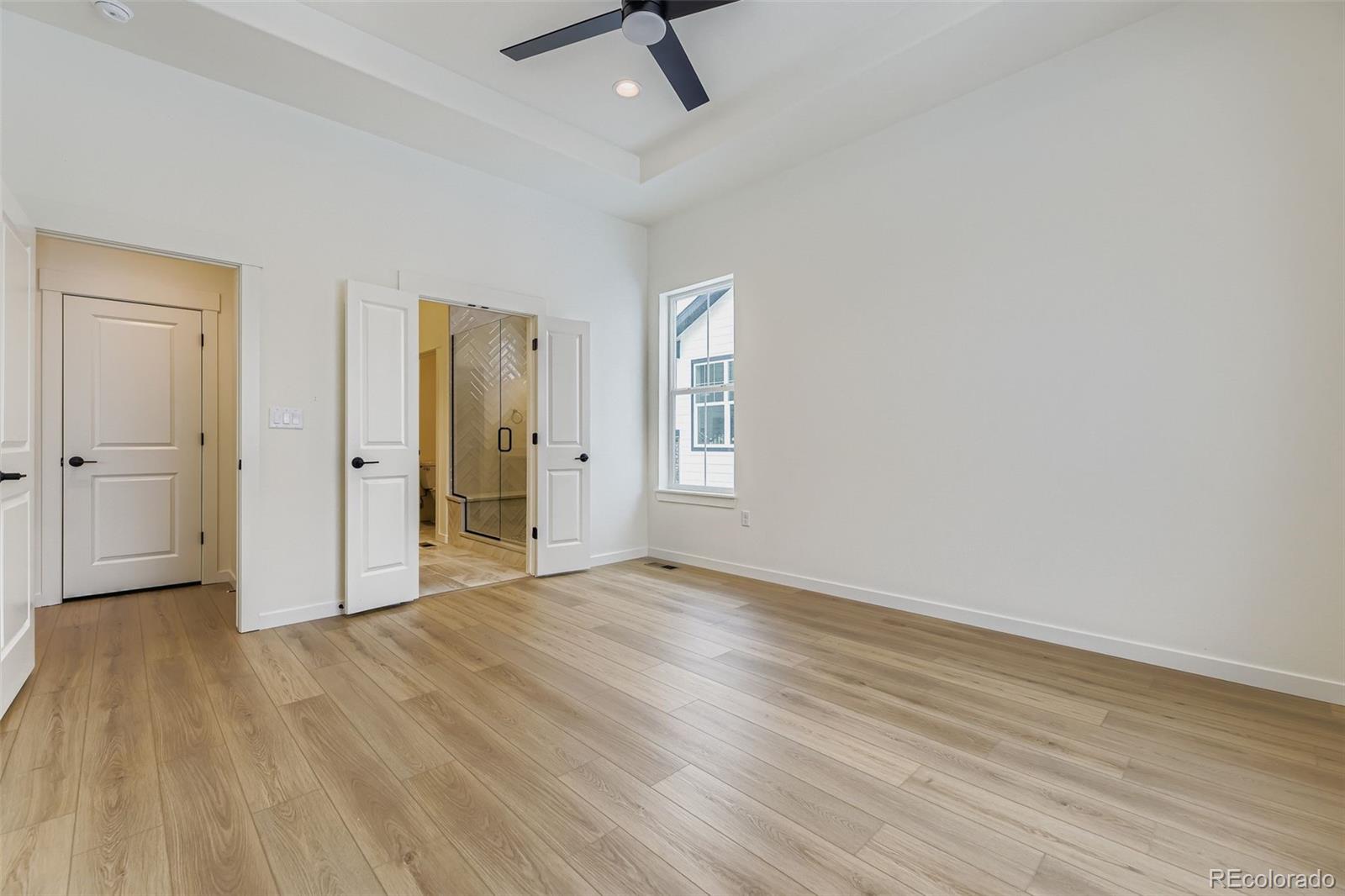 8942 South Riviera Way Aurora, CO 80016 - Photo 14 of 29 an empty room with wooden floor and windows