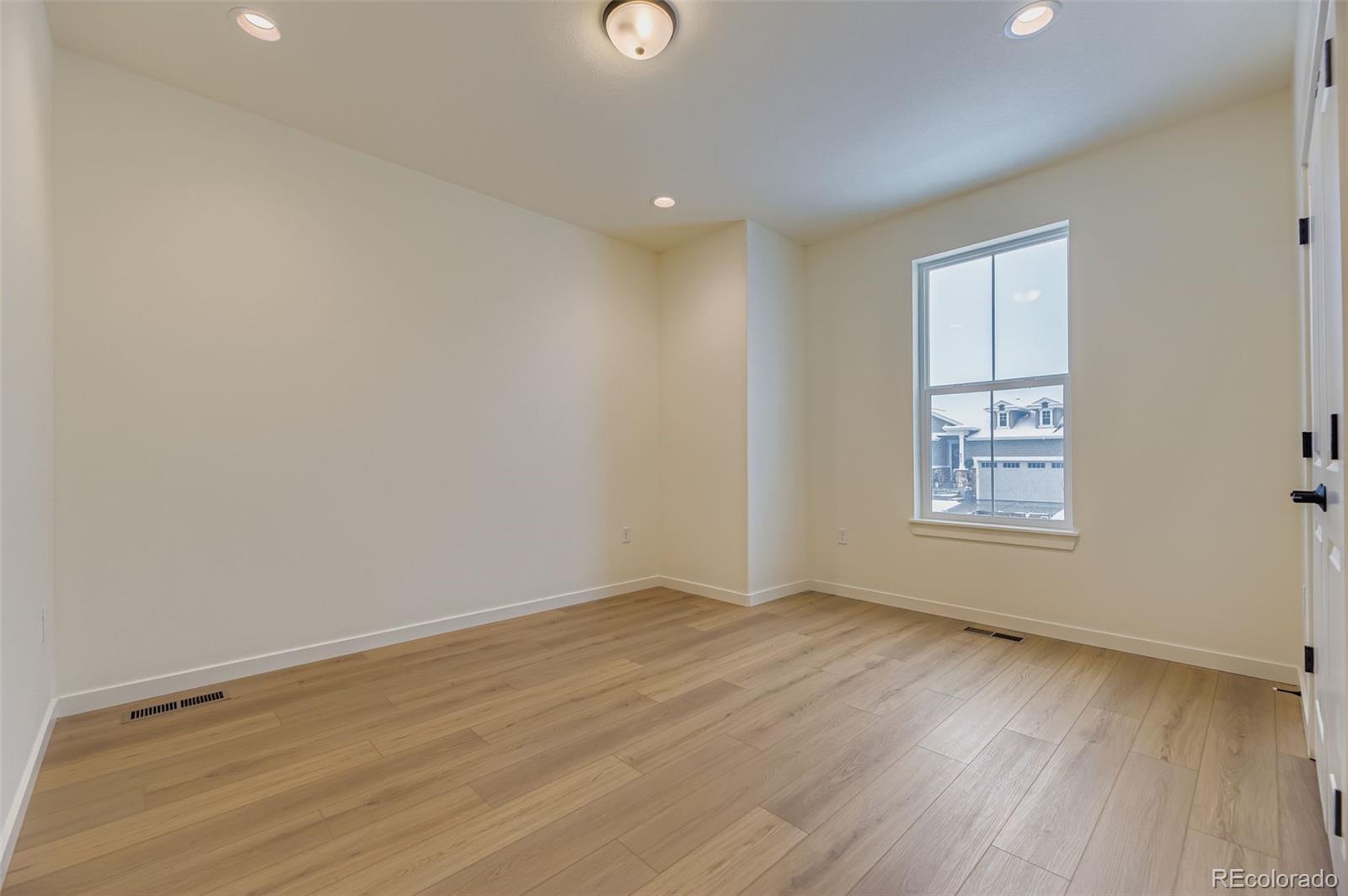 8942 South Riviera Way Aurora, CO 80016 - Photo 18 of 29 a view of an empty room with wooden floor and a window