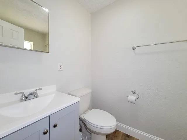a bathroom with a sink a toilet and a mirror