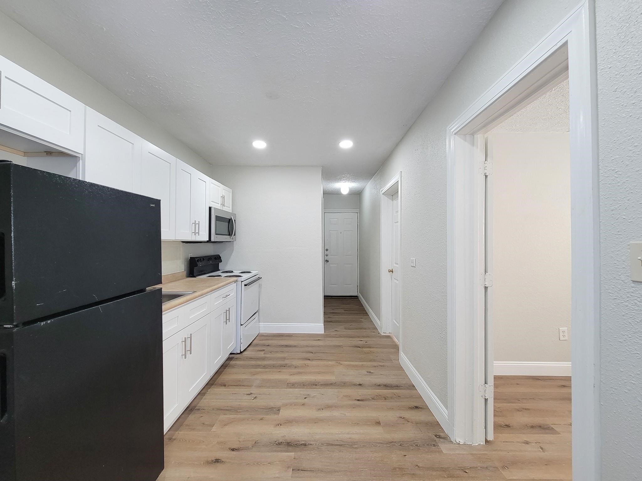 711 Ave A, Unit 1 La Marque, TX 77568 - Photo 13 of 18 a large white kitchen with a stove a refrigerator and a sink