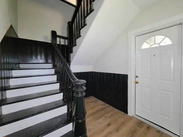 a view of entryway and hall with wooden floor