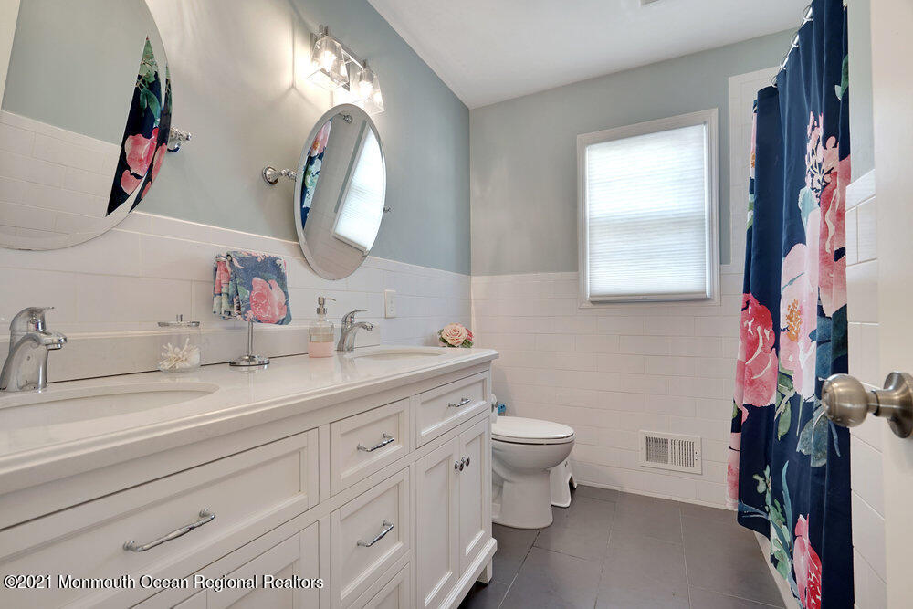 557 Summit Drive Point Pleasant, NJ 08742 - Photo 24 of 41 a bathroom with a double vanity sink and a mirror