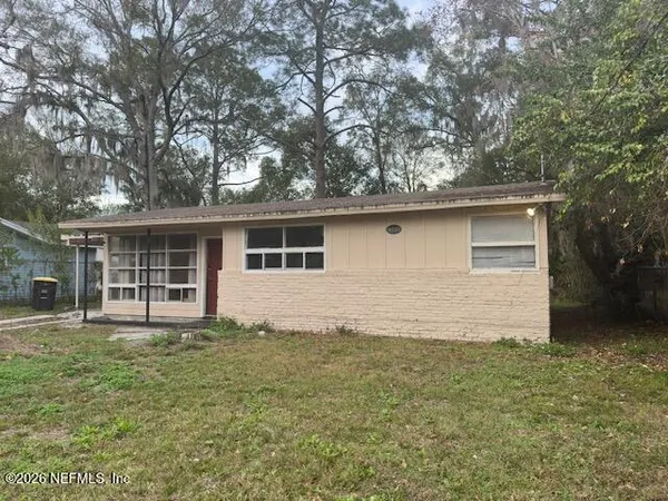 a front view of house with yard and trees in the background