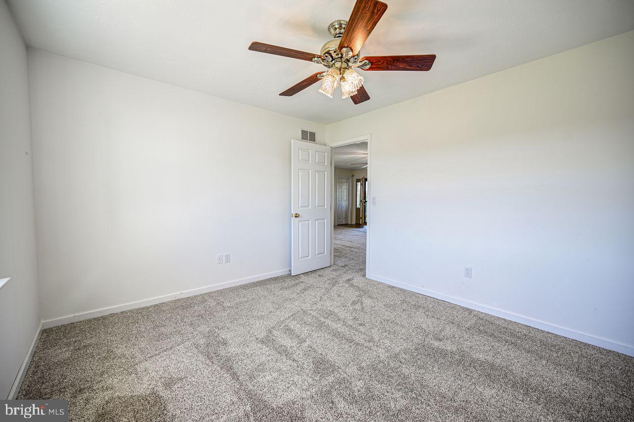 1537 Snyder Corner Road Red Lion, PA 17356 - Photo 25 of 50 an empty room with a chandelier fan and windows