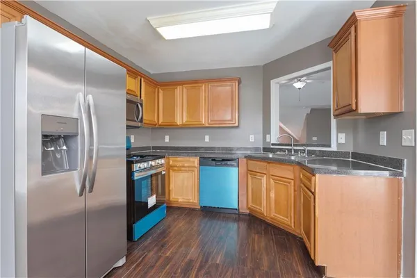 a kitchen with stainless steel appliances granite countertop a sink a stove and refrigerator