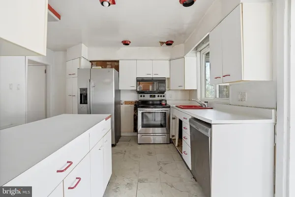 a kitchen with stainless steel appliances cabinets and a window