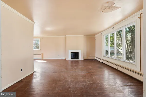 an empty room with wooden floor and fireplace