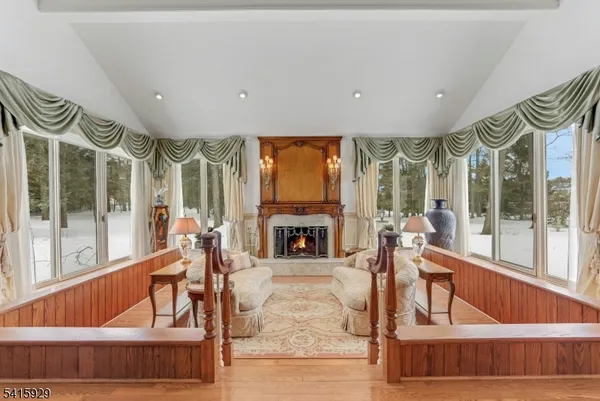 a living room with fireplace furniture and a large window