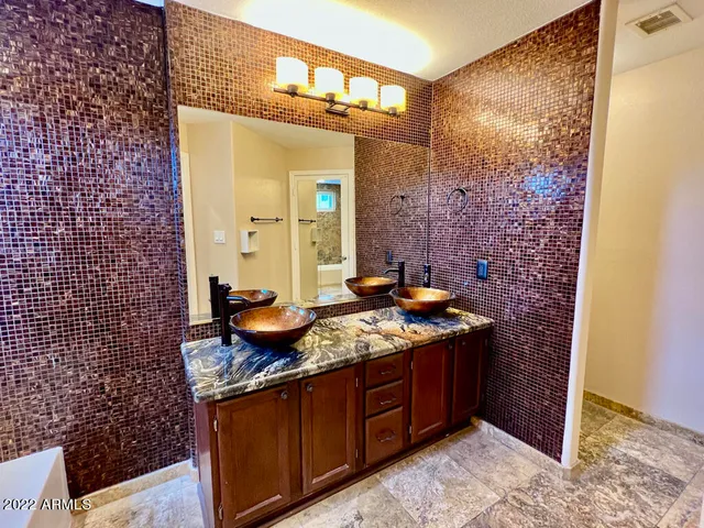 a bathroom with a granite countertop sink a mirror and a shower