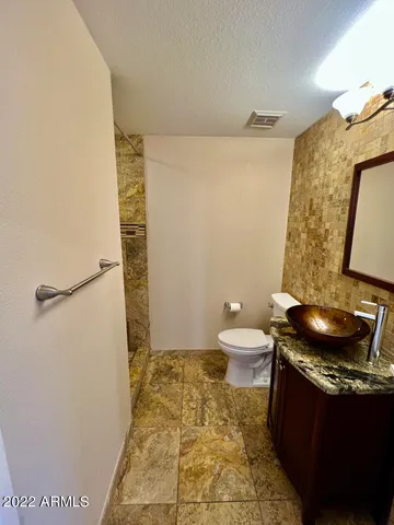 a bathroom with a granite countertop sink toilet and shower