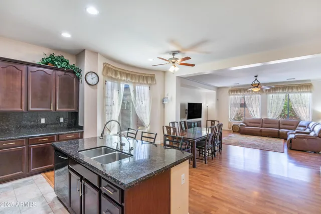 a kitchen with stainless steel appliances kitchen island granite countertop a refrigerator and a sink