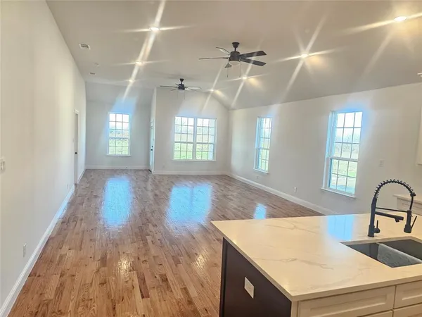 a view of a room with wooden floor and windows