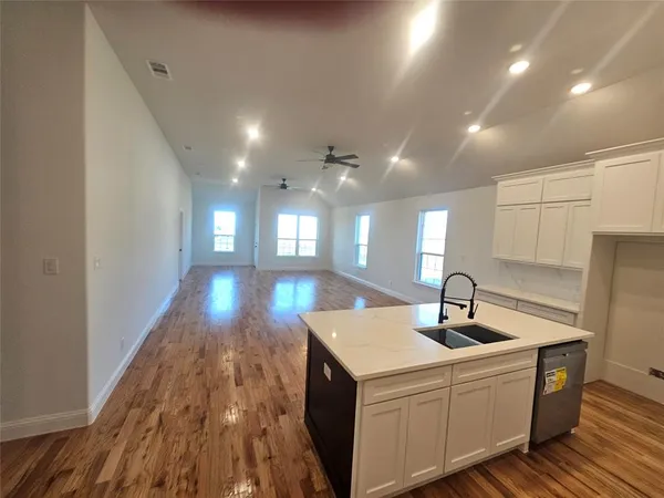 a view of a big room with wooden floor and windows