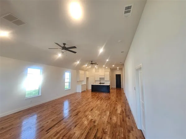 a view of a livingroom with a ceiling fan and wooden floor