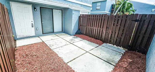 a front view of a house with a yard and palm trees