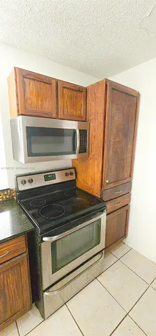 a view of a kitchen with a sink and a refrigerator