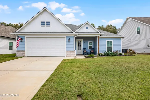 a view of a white house next to a yard and palm tree