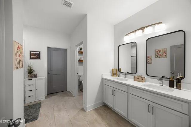 a en suite bathroom with double sink and a mirror