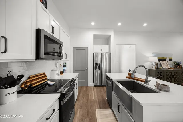 a kitchen that has a sink and a stove top oven