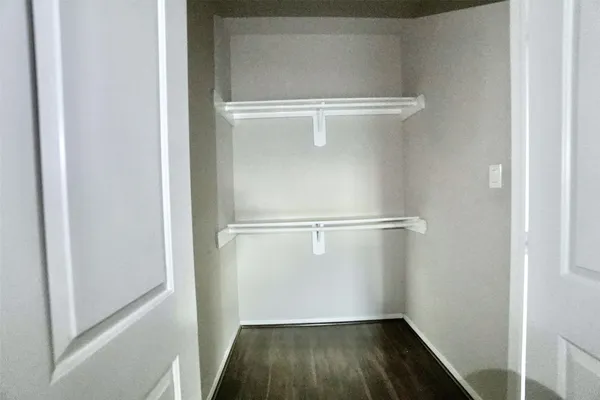 a view of walk in closet with wooden floor