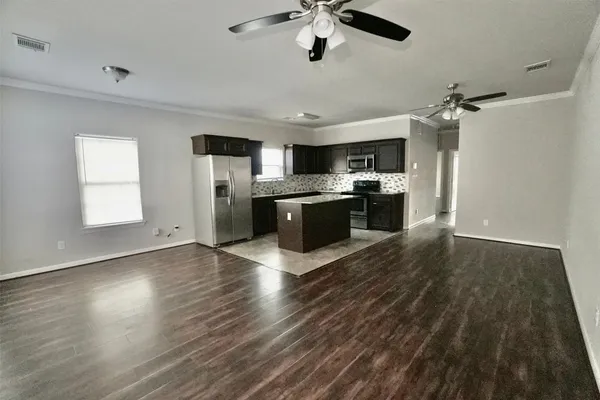 a kitchen with stainless steel appliances granite countertop a refrigerator a stove top oven a sink dishwasher and a refrigerator