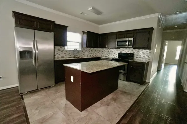 a kitchen with stainless steel appliances granite countertop a stove a sink and a refrigerator